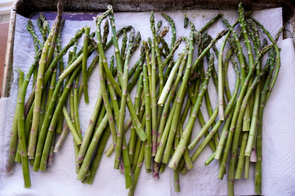asparagus laying on a baking sheet