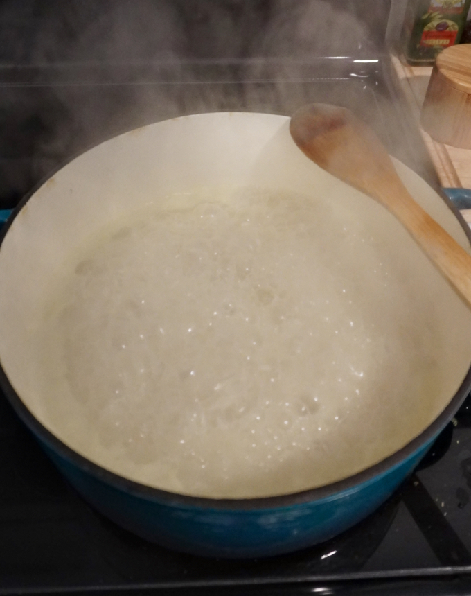 A pot of rice boiling on the stove
