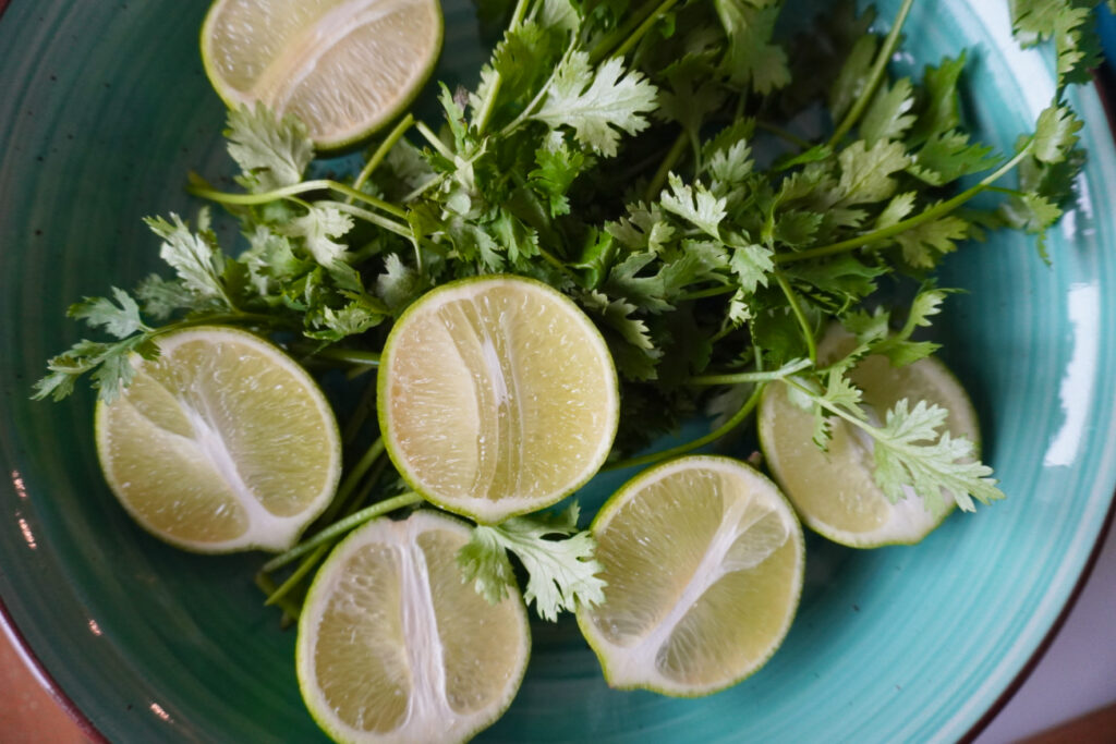 bowl of halved limes and cilantro