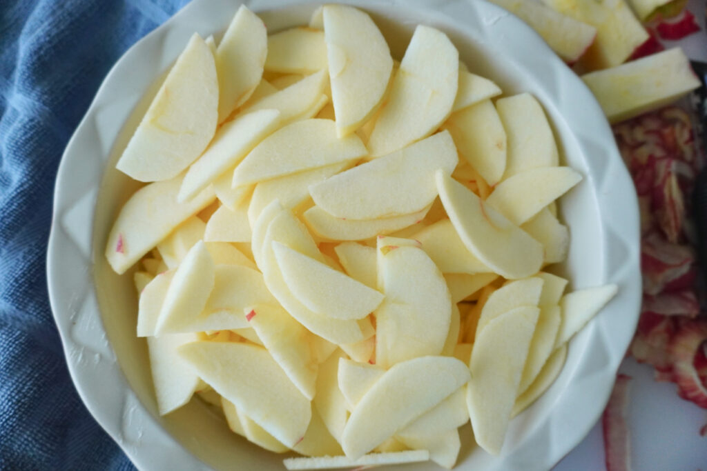 a pie dish of thinly sliced apples