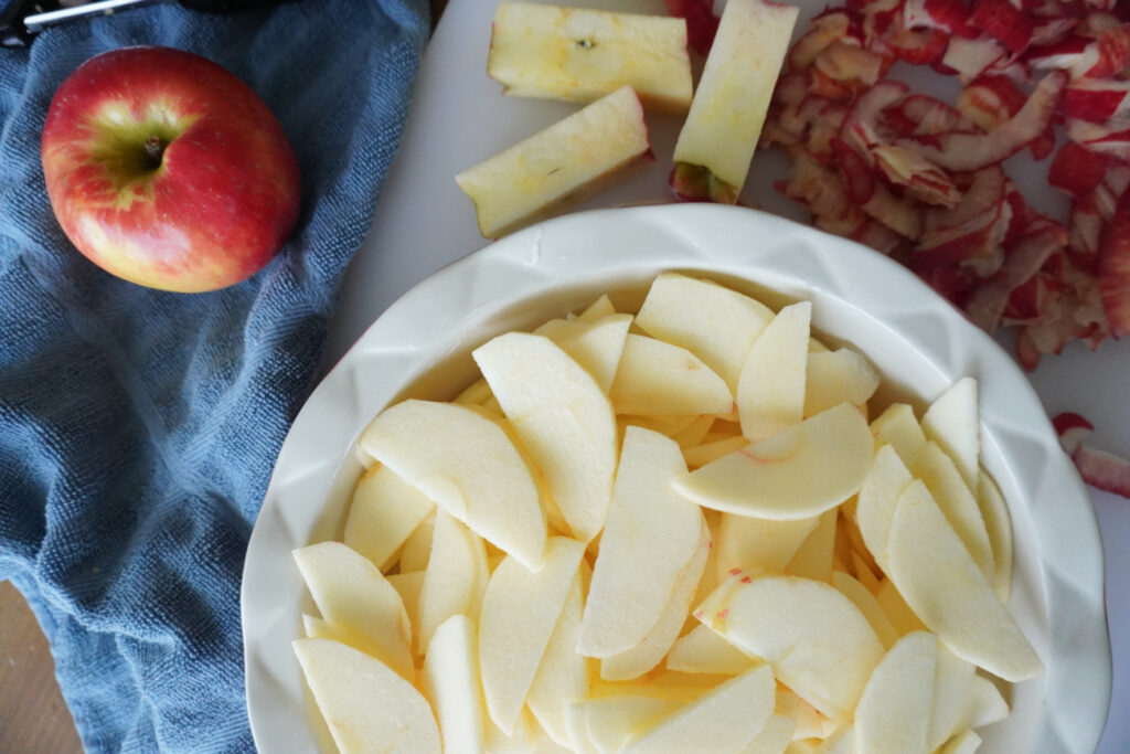 thinly sliced apples in a pie dish 