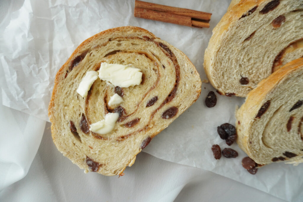 A slice of cinnamon raisin bread with butter on it