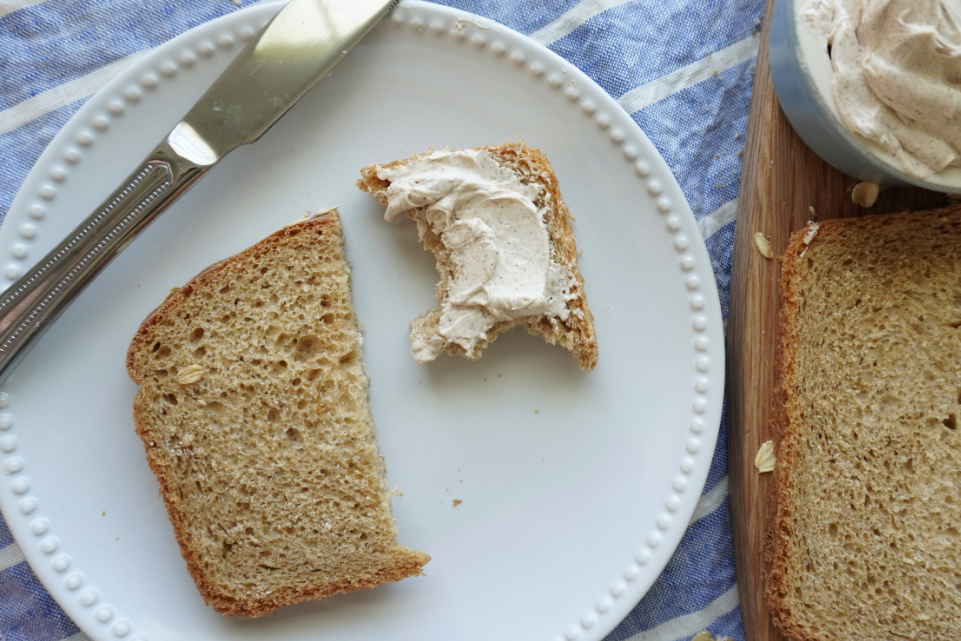 a halved slice of brown bread with butter on it