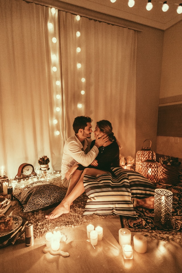 a couple sitting close together and embracing each other in a candlelit room