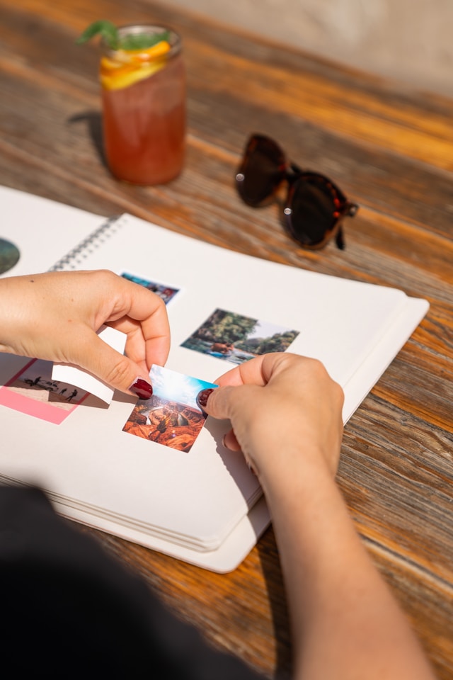 a person placing photos in a photo album