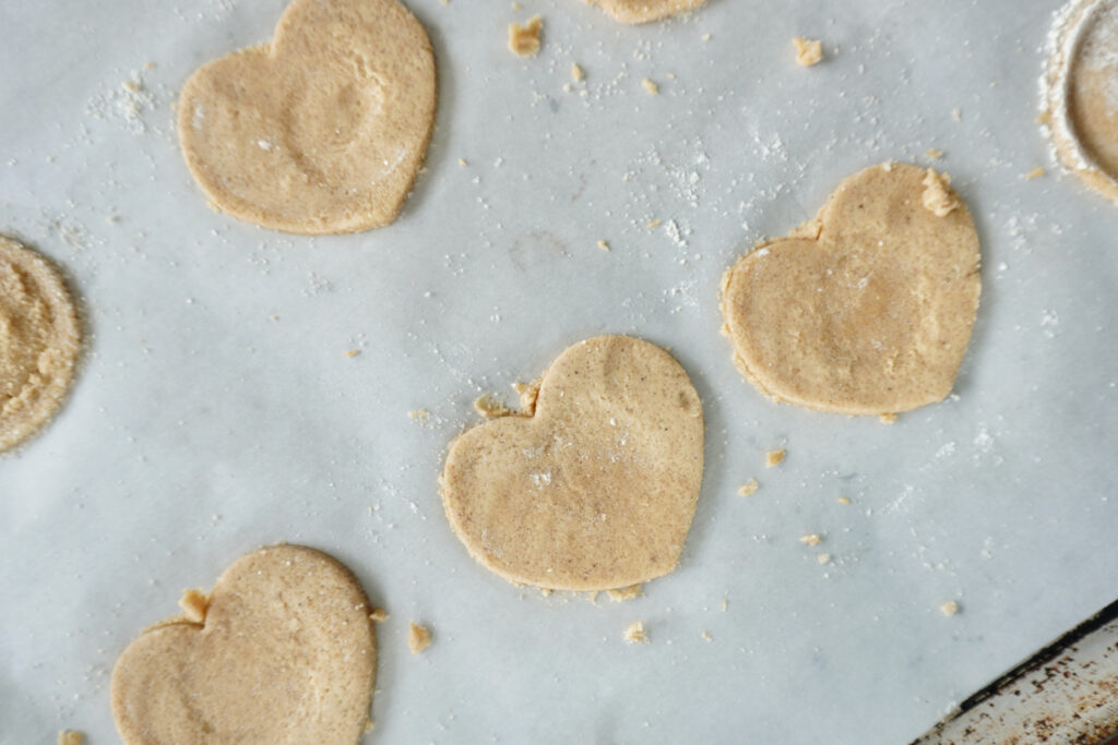 unbaked heart shaped swedish ginger cookies on a baking sheet ready to be baked