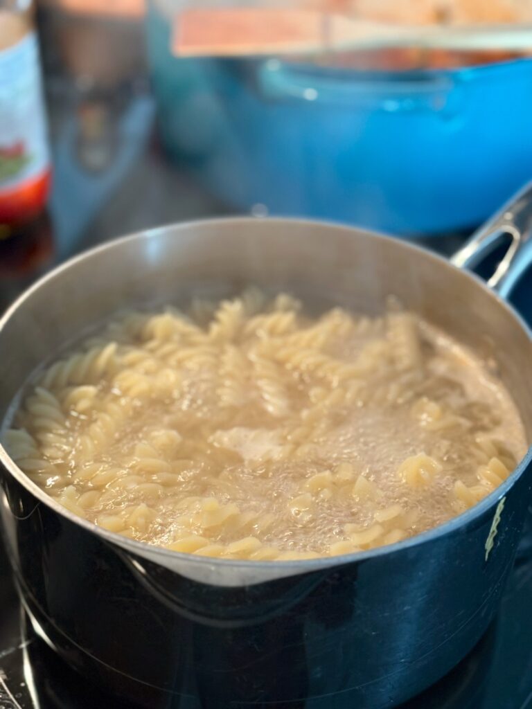a pot of pasta noodles boiling on the stove