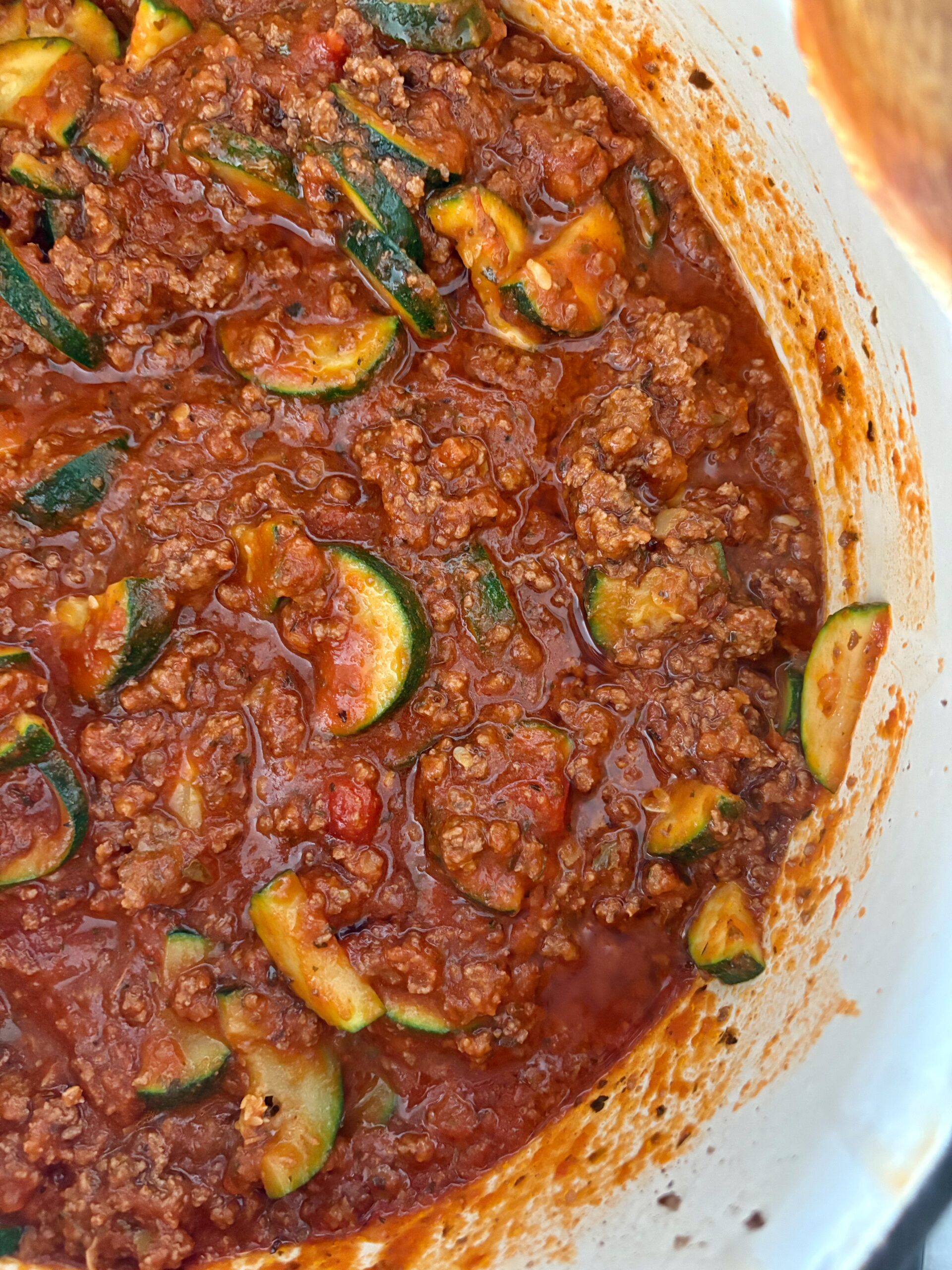 ground beef and zucchini with marinara sauce simmering in a large pot